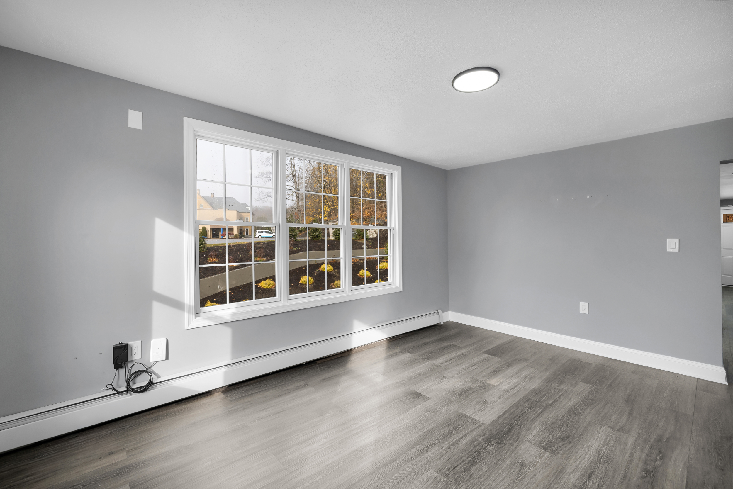 720 Main Street Winchester, CT 06098 - Photo 17 of 38 an empty room with wooden floor and windows