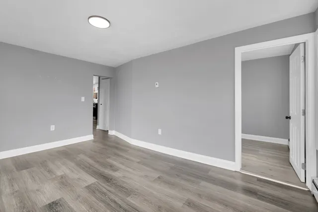 a view of an empty room with wooden floor