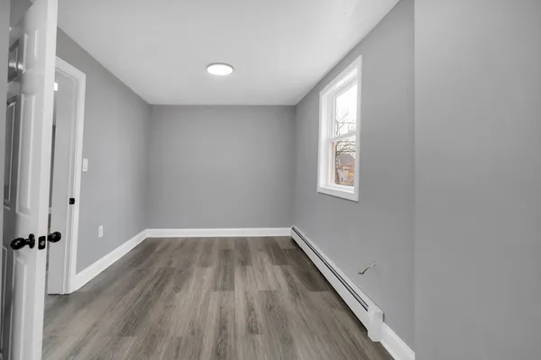 wooden floor in an empty room with a window
