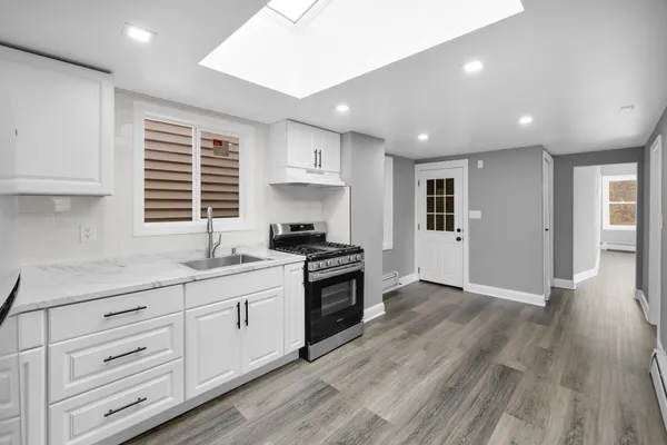 a kitchen with granite countertop a stove and a sink