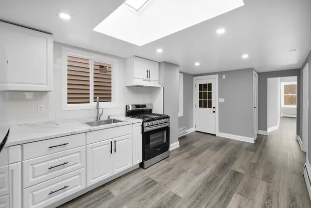a kitchen with granite countertop a stove and a sink