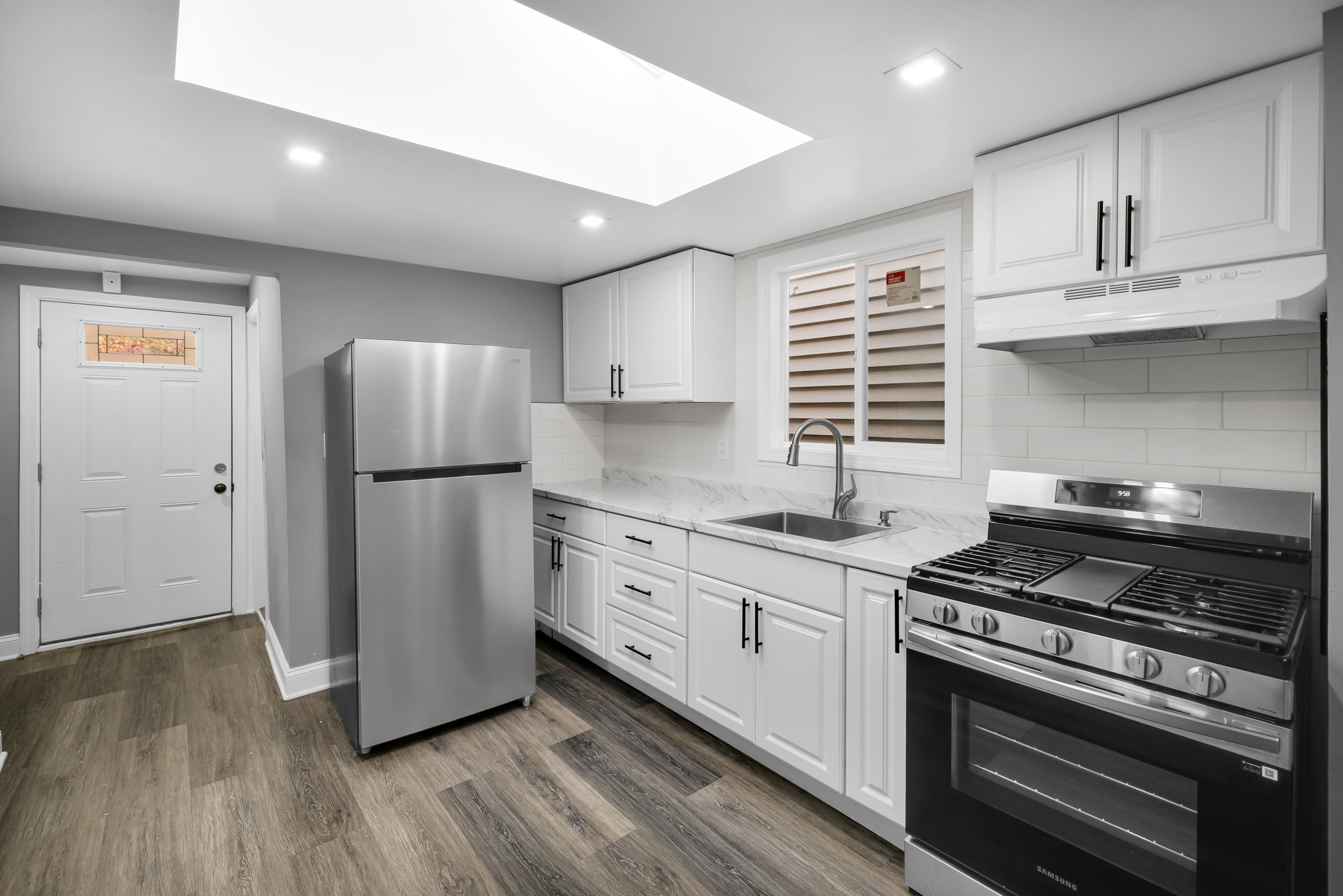 720 Main Street Winchester, CT 06098 - Photo 28 of 38 a kitchen with appliances a sink cabinets and wooden floor
