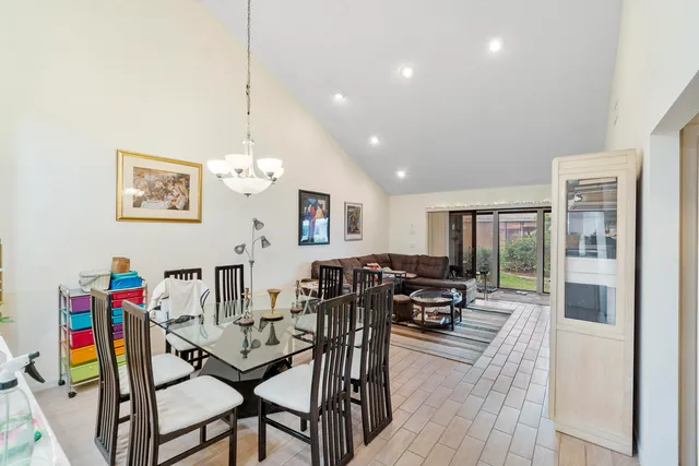 a view of a dining room with furniture a chandelier and wooden floor