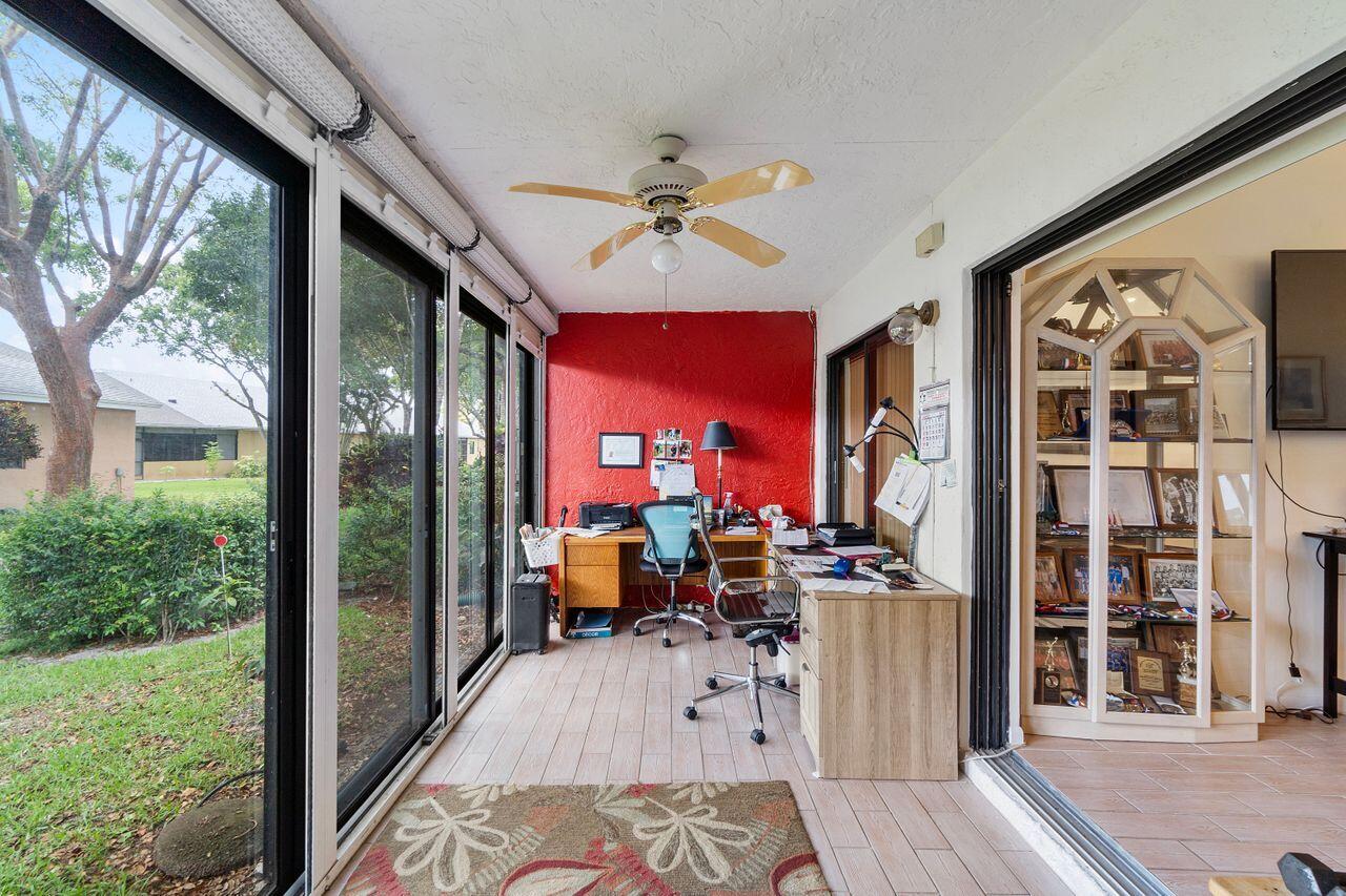 10900 Waterberry Court Boca Raton, FL 33498 - Photo 26 of 28 a living room with furniture a fireplace and a floor to ceiling window