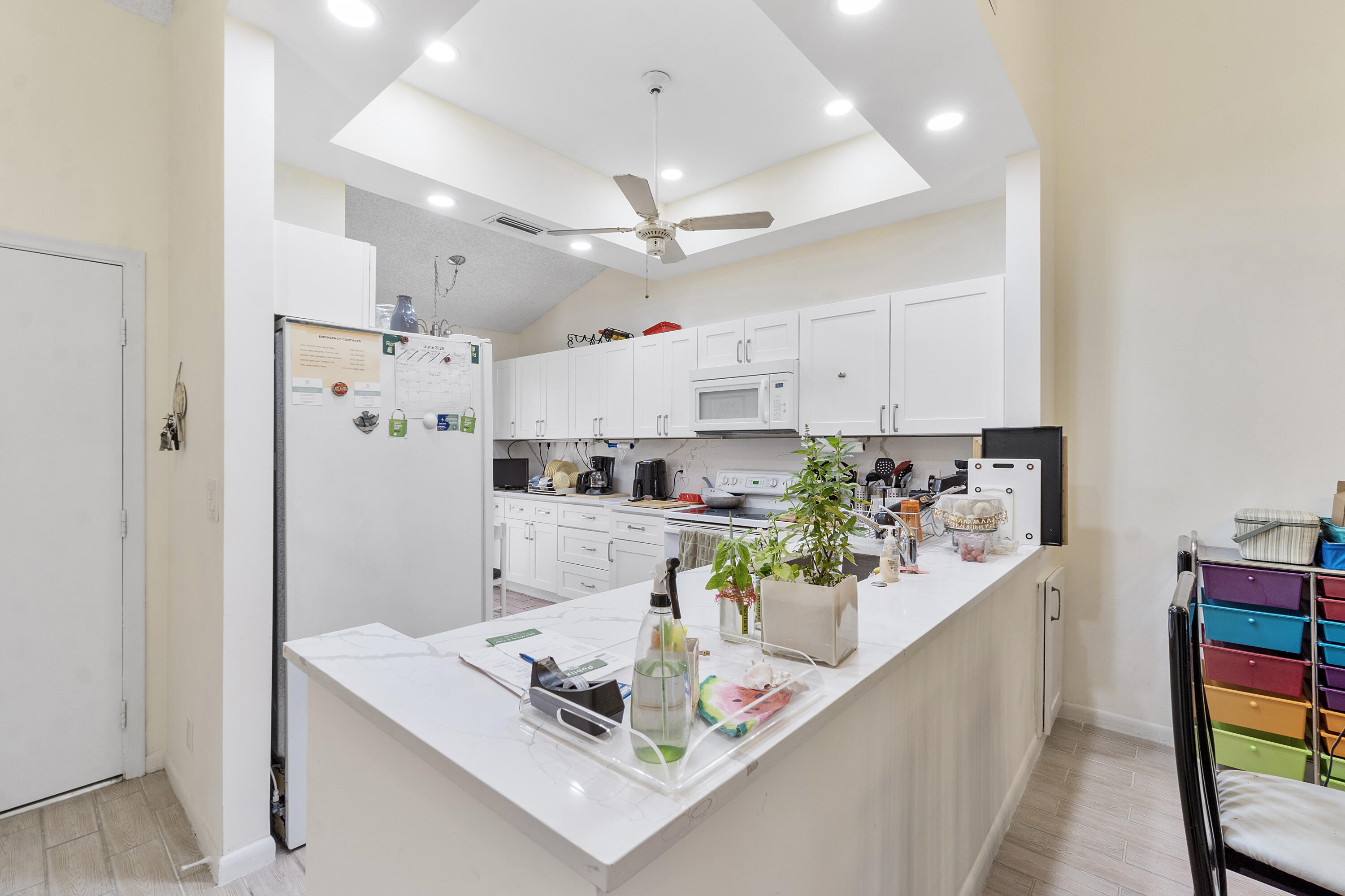 10900 Waterberry Court Boca Raton, FL 33498 - Photo 9 of 28 a kitchen with stainless steel appliances granite countertop a refrigerator a stove a sink dishwasher and white cabinets with wooden floor