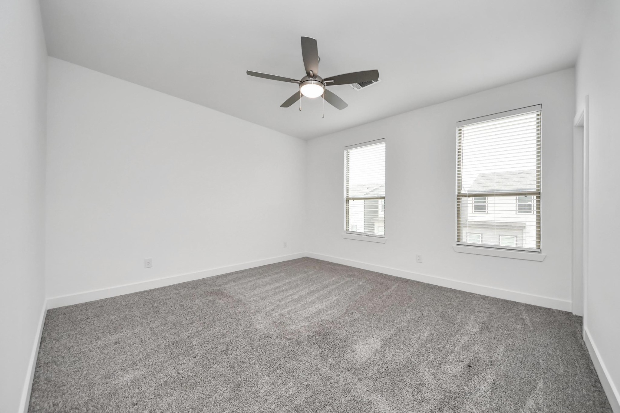 18527 Centro Row Conroe, TX 77385 - Photo 32 of 44 Tall windows and a ceiling fan make this additional bedroom an inviting space for guests or a dedicated creative studio.
