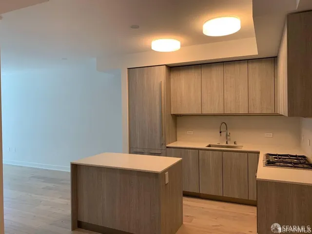 a kitchen with a sink a cabinets and wooden floor