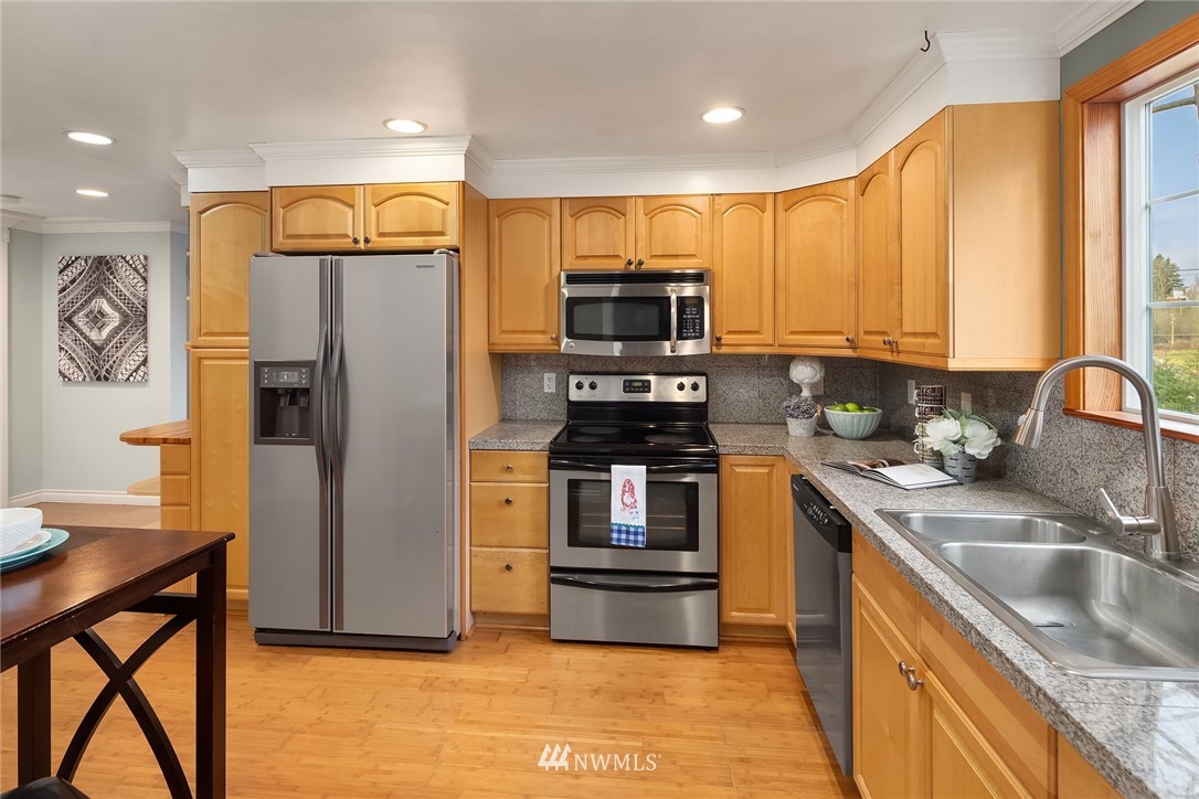 458 Grandey Way Northeast Renton, WA 98056 - Photo 6 of 18 a kitchen with stainless steel appliances granite countertop a refrigerator a stove top oven a sink and dishwasher
