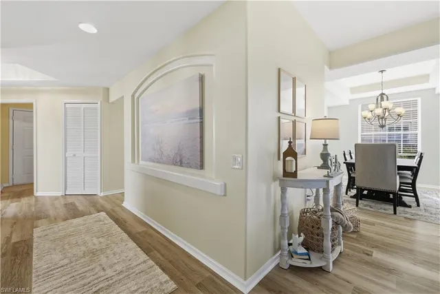 a view of a hallway with wooden floor windows and a livingroom
