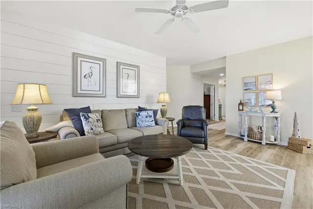 a living room with furniture a large window and a chandelier