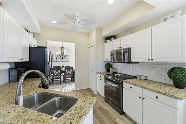 a kitchen with stainless steel appliances granite countertop a sink a stove and cabinets