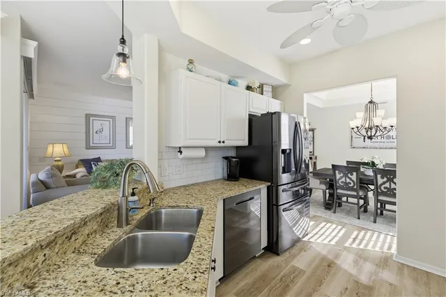 a kitchen with granite countertop a sink appliances and cabinets