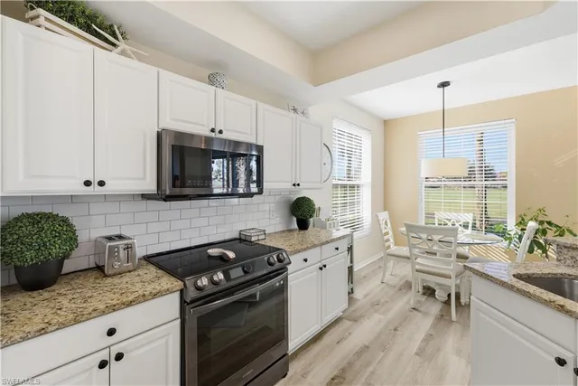 a kitchen with stainless steel appliances granite countertop a sink stove and cabinets