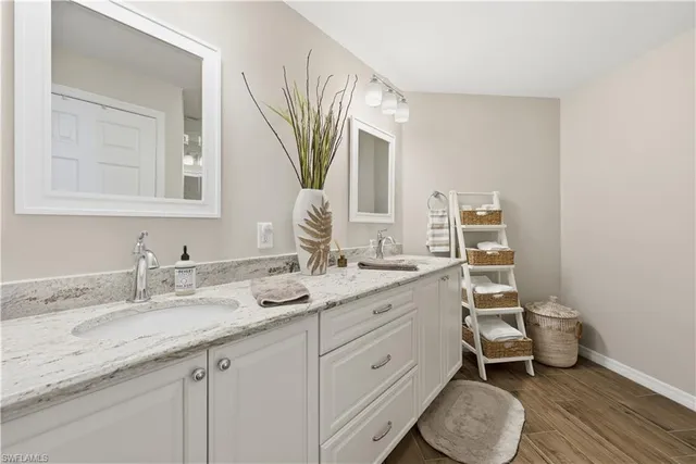 a bathroom with a granite countertop toilet sink and mirror