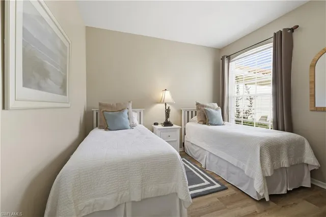 a bedroom with two beds and large window