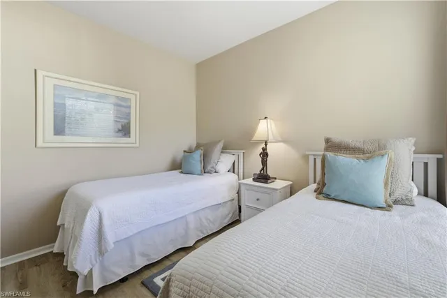 a bedroom with two beds and painting on the wall