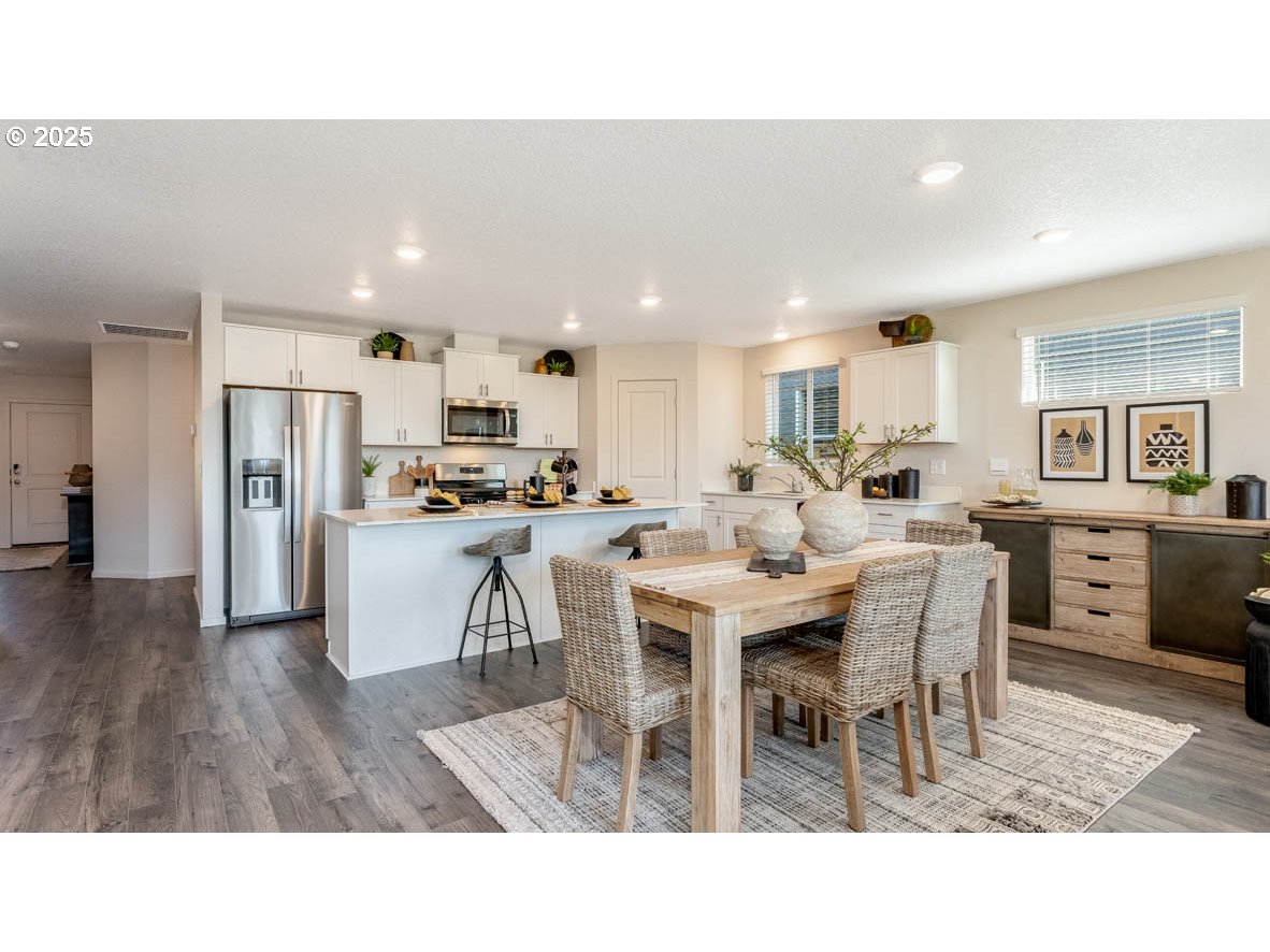 348 Greencrest Street Northeast Salem, OR 97301 - Photo 16 of 26 a living room with stainless steel appliances kitchen island granite countertop a dining table chairs and a refrigerator