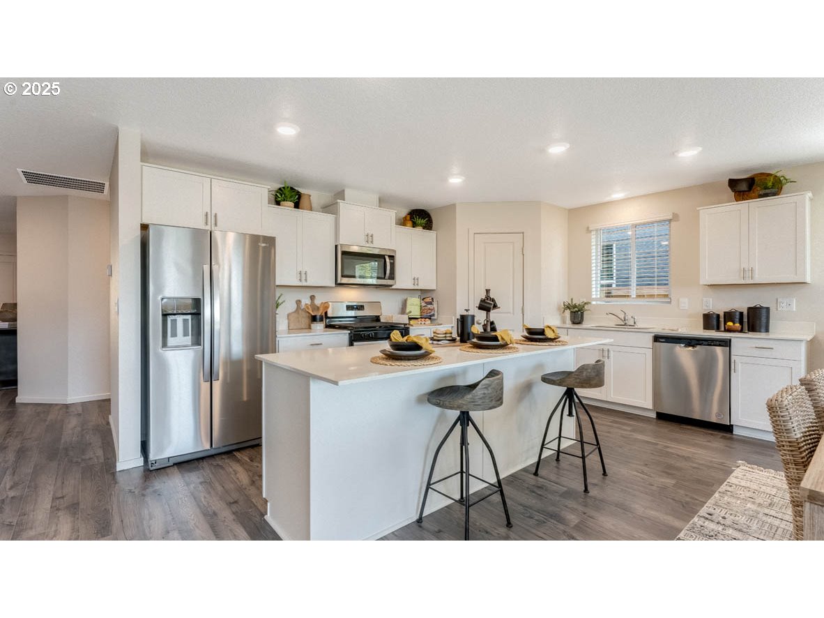348 Greencrest Street Northeast Salem, OR 97301 - Photo 10 of 26 a kitchen with refrigerator a sink a stove a dining table and chairs