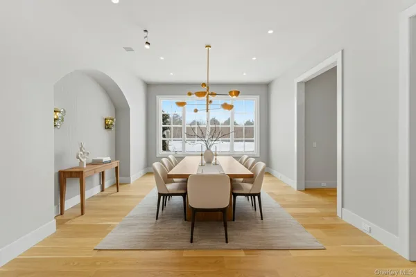 a dining room with furniture a chandelier and wooden floor