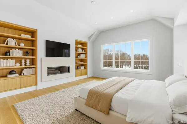a bedroom with a bed a fireplace and a television