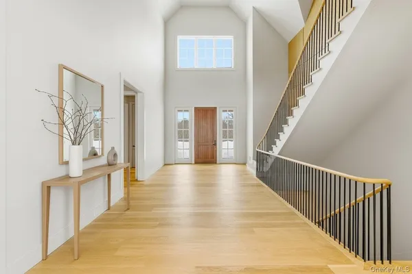 a view of a hallway with wooden floor and staircase