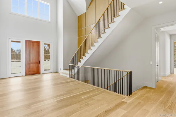 a view of a hallway with wooden floor and windows