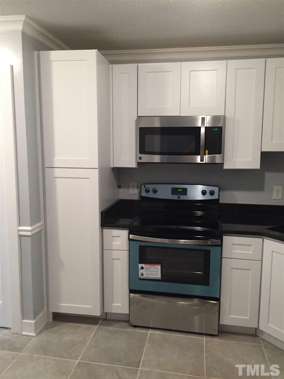 1439 Quarter Point Raleigh, NC 27615 - Photo 8 of 14 a kitchen with white cabinets and stainless steel appliances