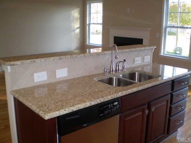 5810 Spring Glen Lane Raleigh, NC 27616 - Photo 6 of 12 a kitchen with a granite counter top space a sink and a window