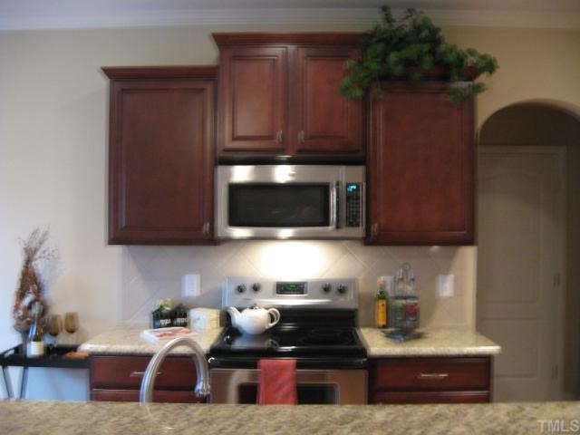 5810 Spring Glen Lane Raleigh, NC 27616 - Photo 7 of 12 a kitchen with stainless steel appliances granite countertop a stove a microwave a sink and cabinets