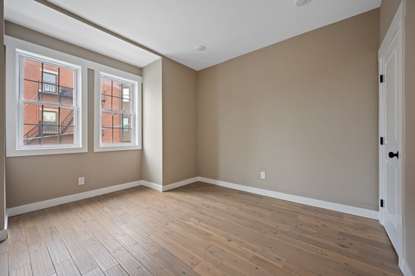 5 Monmouth Street Boston, MA 02128 - Photo 28 of 40 an empty room with wooden floor and windows