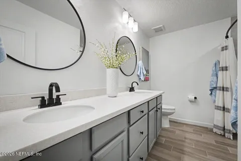a bathroom with a double vanity sink and a mirror