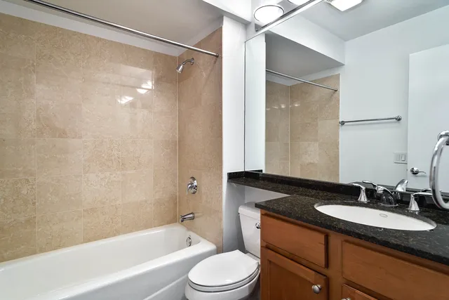 a bathroom with a granite countertop sink toilet and shower