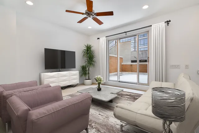 a living room with furniture floor to ceiling window and a flat screen tv