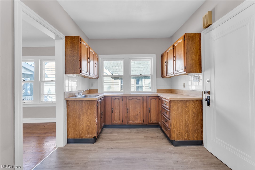 1499 Sherbrook Road South Euclid, OH 44121 - Photo 12 of 41 Kitchen with backsplash, sink, and light hardwood floors