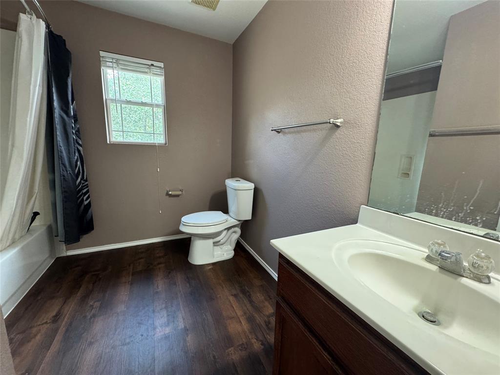 3200 Crownover Street Austin, TX 78725 - Photo 17 of 23 Rich hardwood floors create a welcoming atmosphere in this well-appointed bathroom.