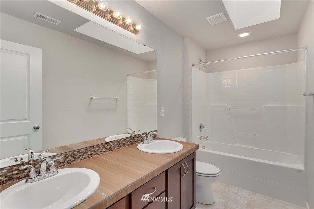 18504 115th Place Southeast Renton, WA 98055 - Photo 30 of 40 a bathroom with a sink a toilet a mirror and shower