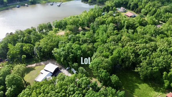 an aerial view of residential house with outdoor space and trees all around