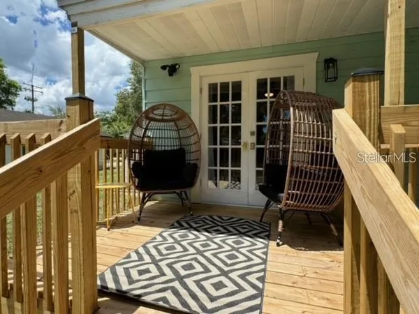 a view of a balcony with a potted plant and wooden floor