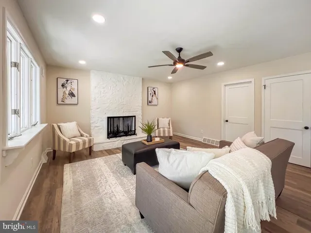 a living room with furniture ceiling fan and a wooden floor