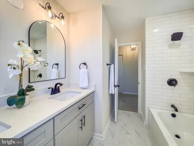 a bathroom with a tub sink and mirror