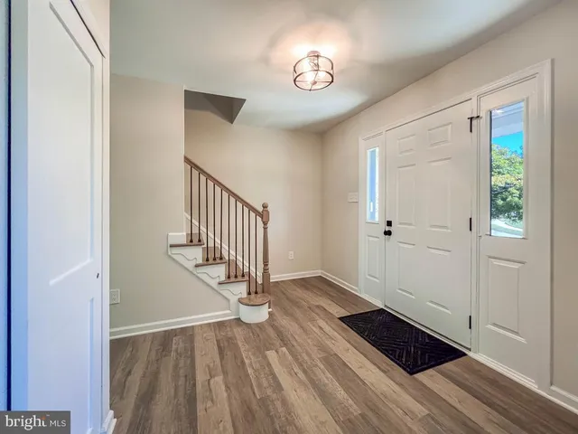 a view of a hallway with wooden floor and staircase