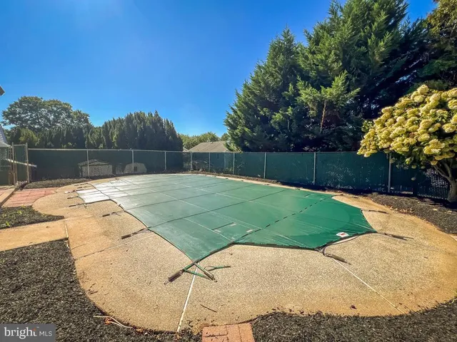 a swimming pool with outdoor seating and garden
