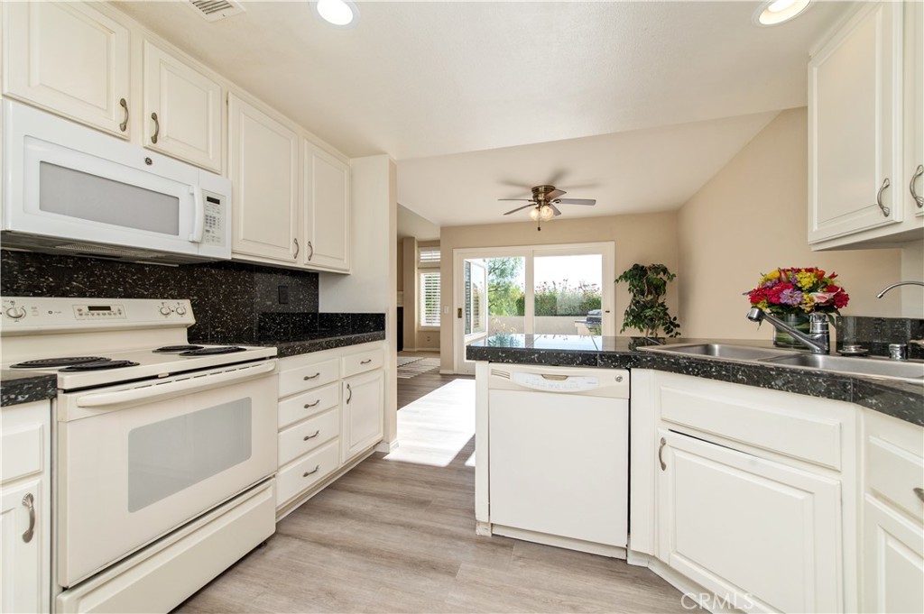 335 Stanford Court Irvine, CA 92612 - Photo 13 of 31 a kitchen with granite countertop white cabinets and white appliances