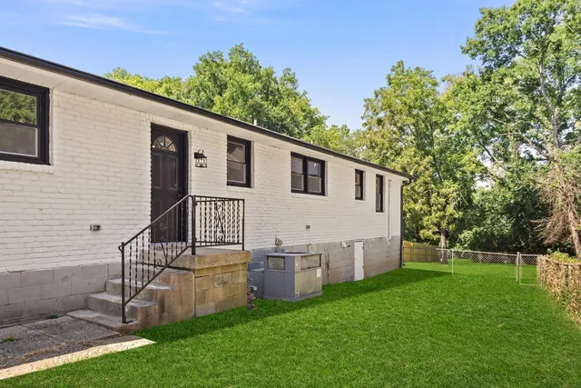 a view of backyard with barbeque grill and a small yard