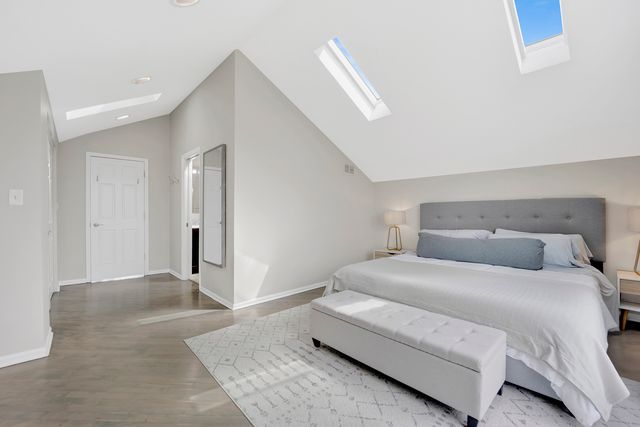 a bedroom with a large bed and a chandelier