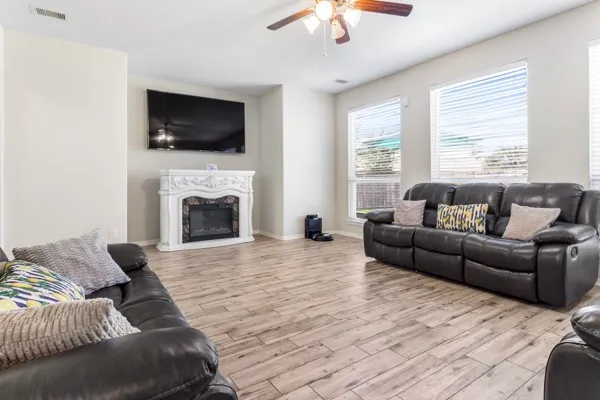 a kitchen with stainless steel appliances granite countertop a stove a sink dishwasher a refrigerator and wooden cabinets with wooden floor