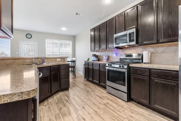 a kitchen with stainless steel appliances granite countertop a sink stove and refrigerator