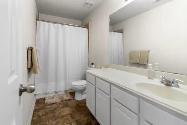 a bedroom with a bed and a flat tv screen on dresser