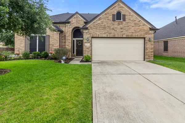 a front view of a house with a yard and trees