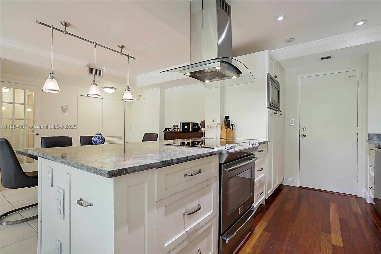 1700 Northeast 105th Street, Unit 203 Miami Shores, FL 33138 - Photo 11 of 45 a kitchen with a sink dishwasher a stove and a refrigerator with wooden floor
